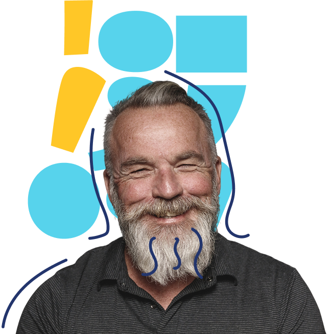 A smiling older man with a gray beard and mustache, wearing a dark shirt, is pictured in front of a background featuring blue geometric shapes and one yellow exclamation mark. Blue squiggles are drawn on his beard.